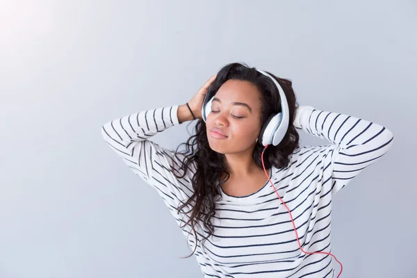 Glad ung kvinna lyssnar på musik — Stockfoto