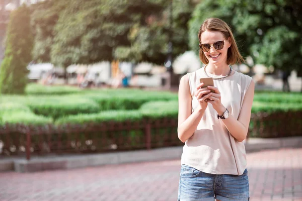 Mooie jonge vrouw met behulp van de telefoon — Stockfoto