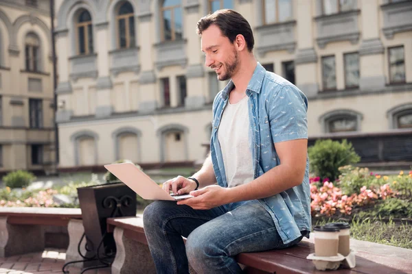 Schöner junger Mann mit Laptop — Stockfoto