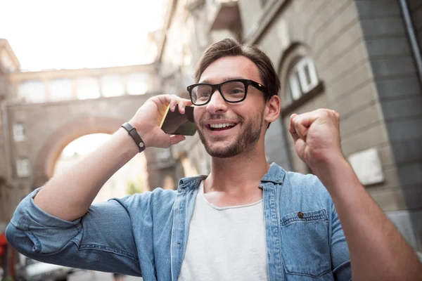 Mutlu genç adam bir telefon görüşmesi yapıyor