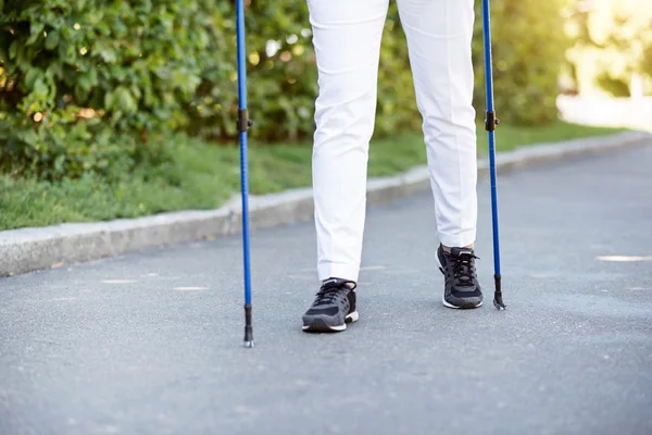 Mujer mayor dando un paseo con palos de seguimiento —  Fotos de Stock