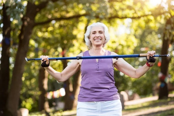 Emekli kadın spor yapıyor sırasında izleme sopa tutarken gülümseyen