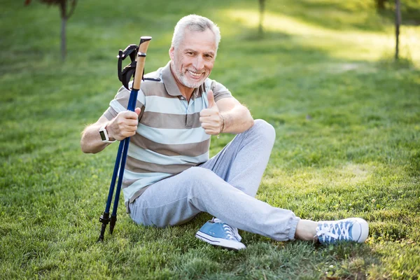 Bello vecchio seduto sull'erba con le gambe incrociate — Foto Stock