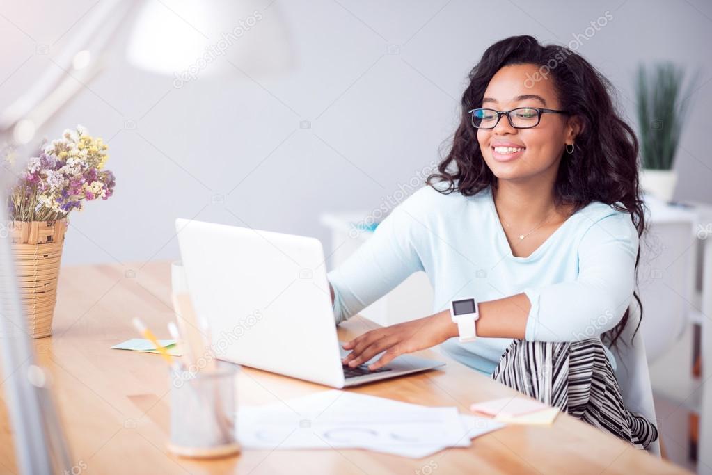 Positive young woman using laptop