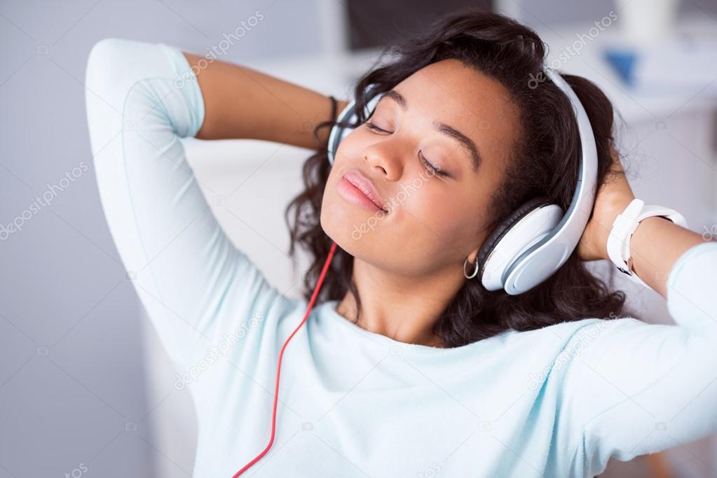 Delighted positive woman listening to music