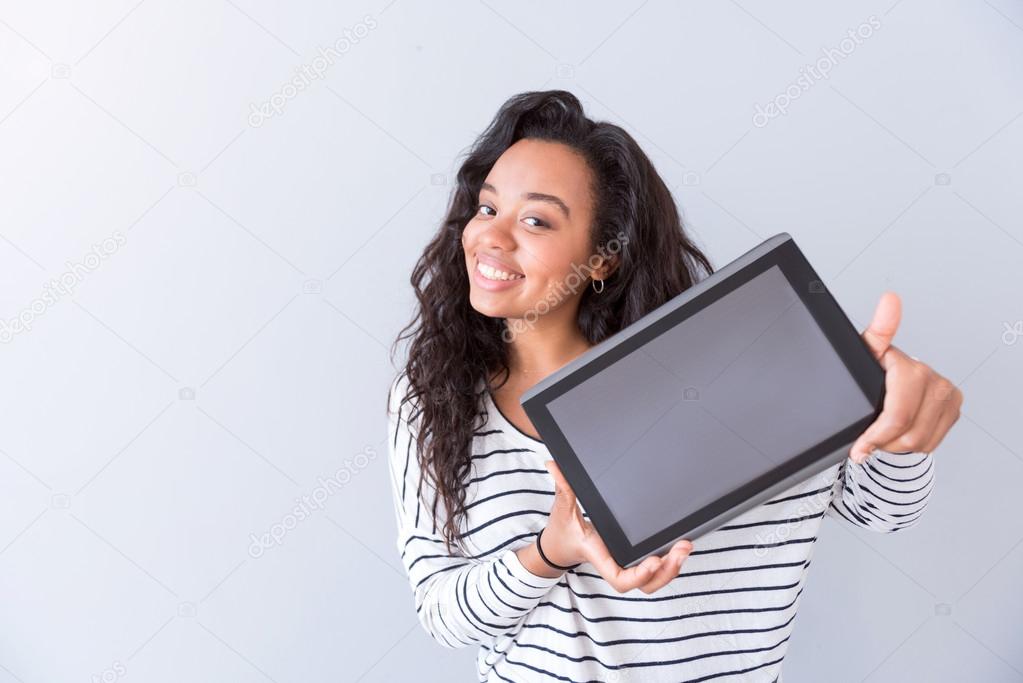 Positive woman holding tablet