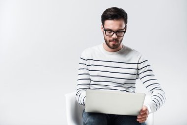 Dizüstü bilgisayar kullanarak konsantre sakallı adam.