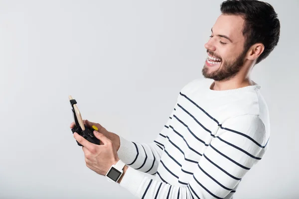 Blij bebaarde man lachen en het gebruik van draagbare gamepad — Stockfoto