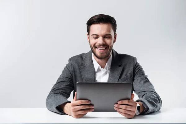 Nöjd skäggiga man leende och använda laptop. — Stockfoto