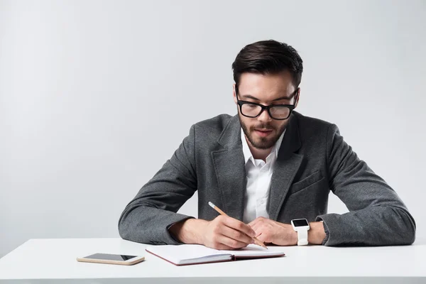 Homme barbu sérieux prenant des notes . — Photo