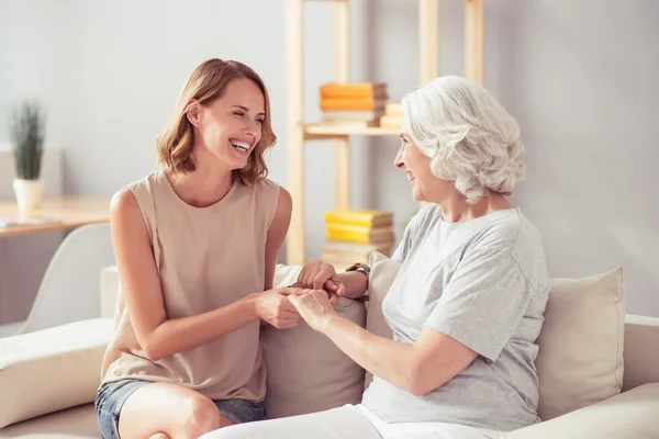 Lustfylld kvinna sitter med sin mormor på soffan — Stockfoto