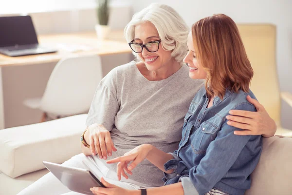 Positive senior woman and her daughter using tablet — Stock Photo, Image