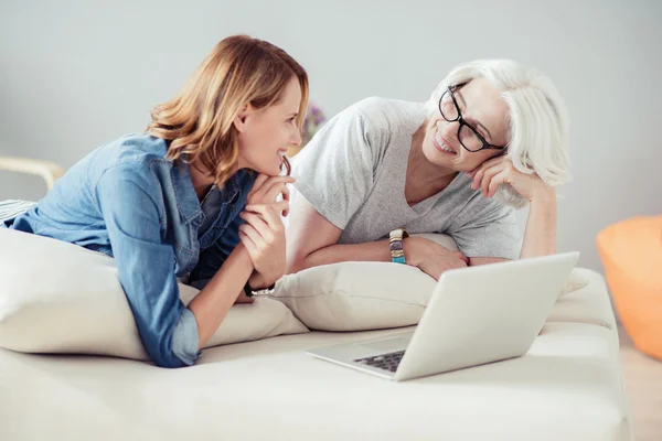 Freudige erwachsene Frau und ihre Mutter, die zu Hause ruht — Stockfoto