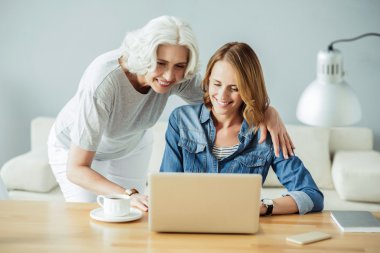 Joyful güzel kadın dizüstü bilgisayar kullanarak