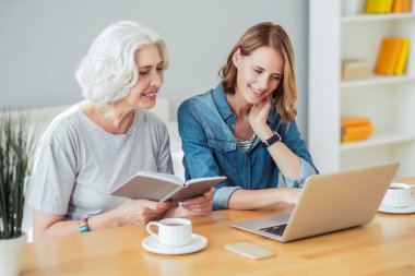 Pozitif kadın ve yetişkin kızı masada oturan