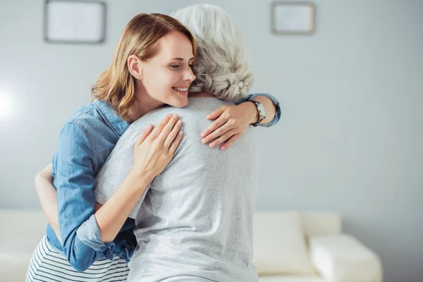 Mulher positiva abraçando com sua mãe — Fotografia de Stock