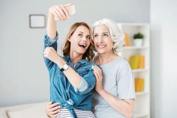 Positiv kvinna som gör selfies med sin mamma — Stockfoto