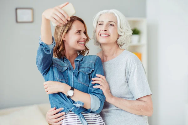 Positivo encantado mulher e sua mãe fazendo selfies — Fotografia de Stock