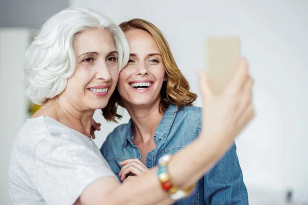 Örömteli magas rangú nő, hogy selfies szellemesség unokája — Stock Fotó