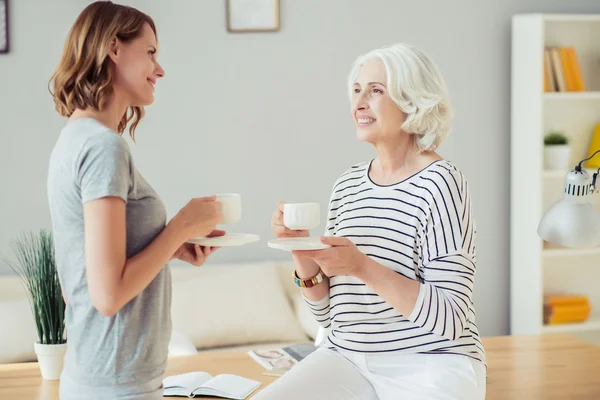 Cheerful woman and her adult daughter drinking tea — Stock Photo, Image