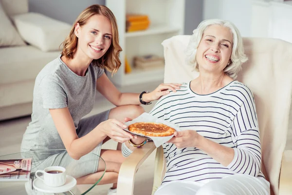 Зачарована усміхнена жінка тримає тарілку з пирогом — стокове фото
