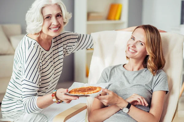 Alegre anciana sosteniendo plato con pastel — Foto de Stock