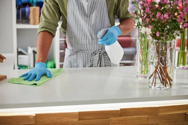 Hombre haciendo limpieza en el mostrador de floristería —  Fotos de Stock