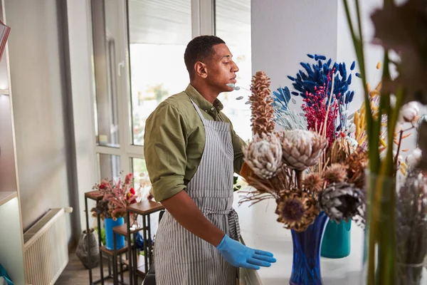 Joven alegre disfrutando del trabajo en la floristería —  Fotos de Stock