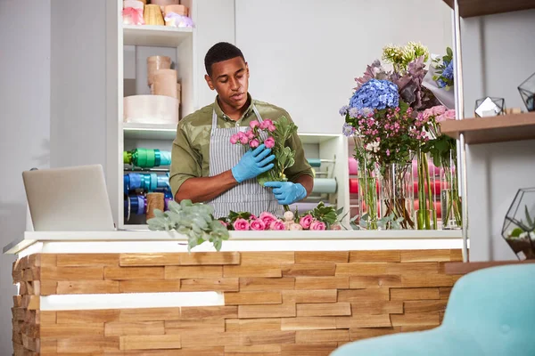 Młoda kwiaciarnia pracuje w sklepie z laptopem — Zdjęcie stockowe