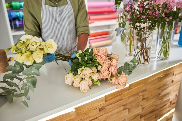 Hombre trabajando con flores frescas en floristería —  Fotos de Stock