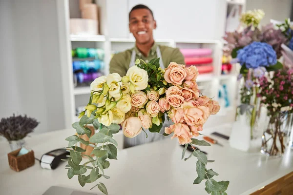Szczęśliwy młody kwiaciarnia prezentuje piękny świeży bukiet — Zdjęcie stockowe
