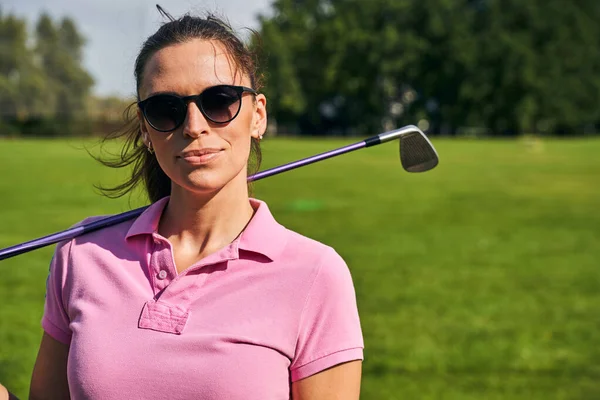 Mujer con un palo de golf de pie afuera —  Fotos de Stock