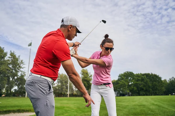 Golfer mastering μια τεχνική swing επικουρείται από τον προπονητή της — Φωτογραφία Αρχείου