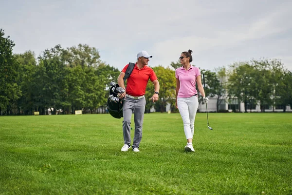 Golfista feminina olhando para seu treinador satisfeito — Fotografia de Stock