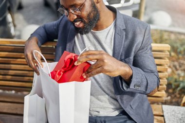 Neşeli sakallı adam arkadaşını bekliyor.