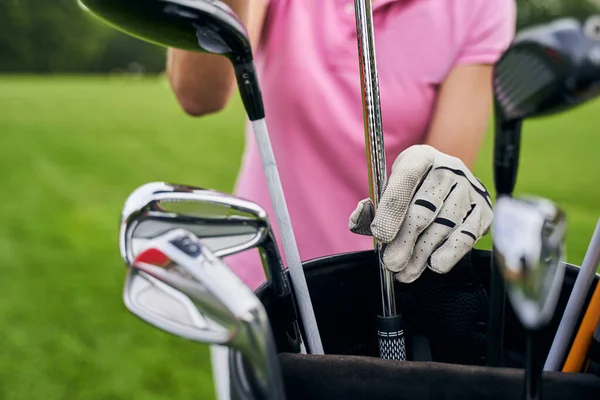 Jogadora escolhe clubes para o jogo de golfe — Fotografia de Stock