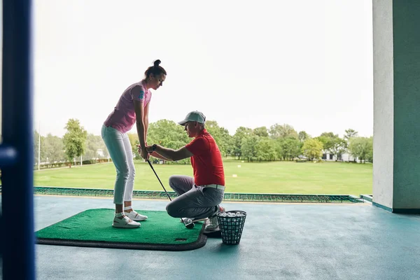 Жінка стоїть на килимку для гольфу — стокове фото