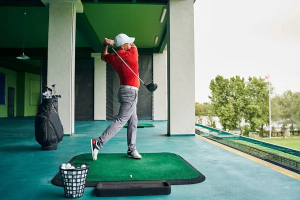 Hombre haciendo ejercicio en la estera de golf —  Fotos de Stock