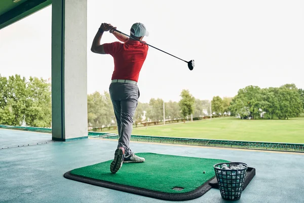 Golfista masculino caucasiano melhorando a técnica do jogo — Fotografia de Stock