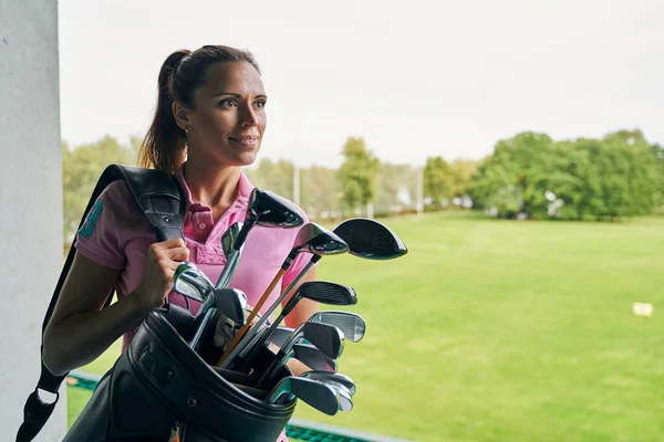 Zufriedene Sportlerin mit Golftasche — Stockfoto