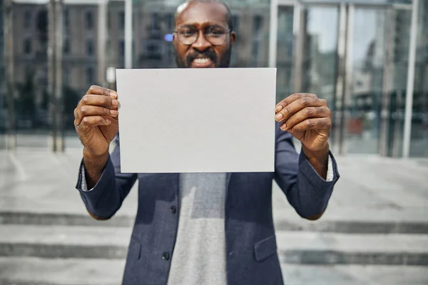 Positivo encantado homem internacional segurando folha de papel — Fotografia de Stock