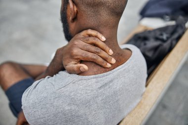 Boynuna dokunan erkeğin eline odaklanmış bir fotoğraf.