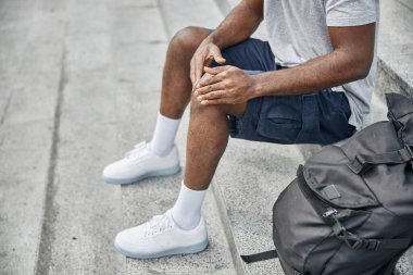 Merdivenlerde oturan yorgun adama yaklaş.