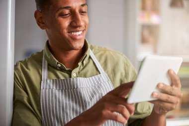 Çiçek uzmanı elinde bir tablet tutarken çok keyifli.