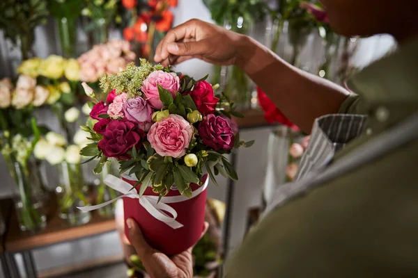 Un employé d'une boutique de fleurs arrachant une feuille d'une rose — Photo