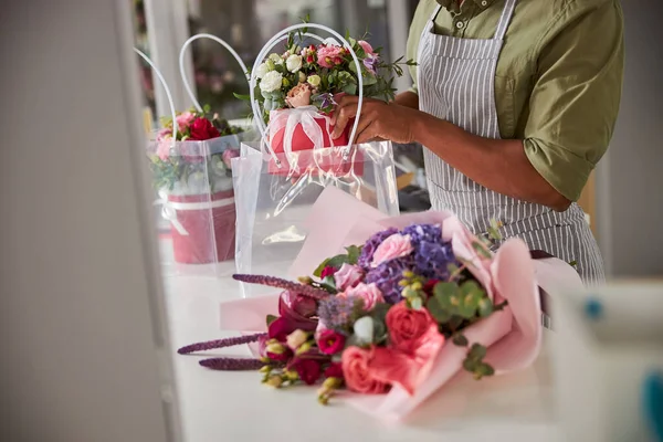 Empleado masculino cargando una maceta de flores a un paquete — Foto de Stock