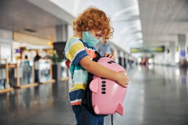 Çocuk sırt çantasında bir şey arıyor.