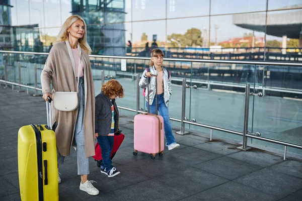 Mutter fährt mit ihren Kindern zum Flughafen — Stockfoto
