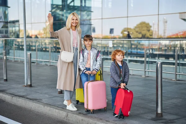 Frau winkt zum Abschied und legt den Arm um ihre Tochter — Stockfoto