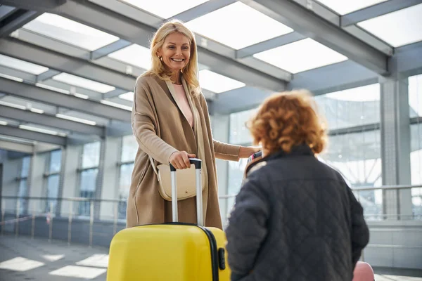 Tevreden vrouw van middelbare leeftijd die naar een kind kijkt — Stockfoto